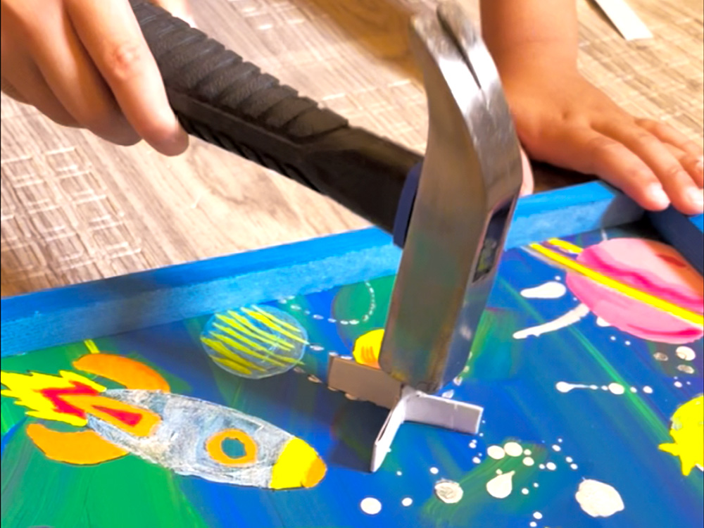 板に絵を描き、釘の位置を考えながら金づちで打ち、ビー玉が転がる道を作る工作
